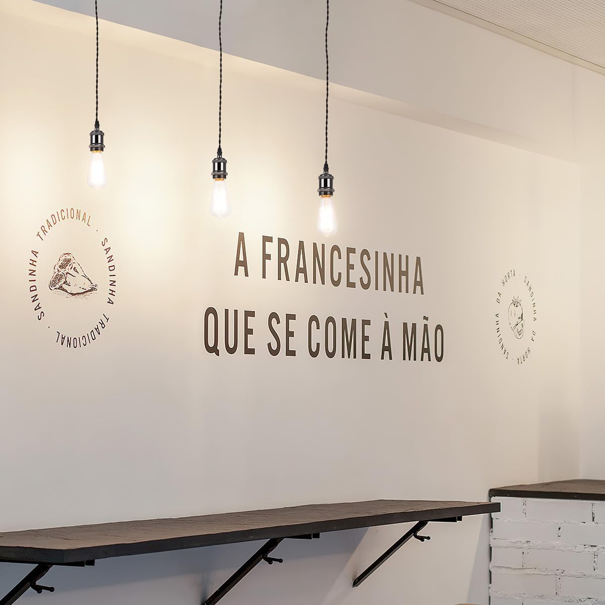 Kiven black pendant lights with Edison bulbs, Portuguese text on wall, suitable for industrial-style decor