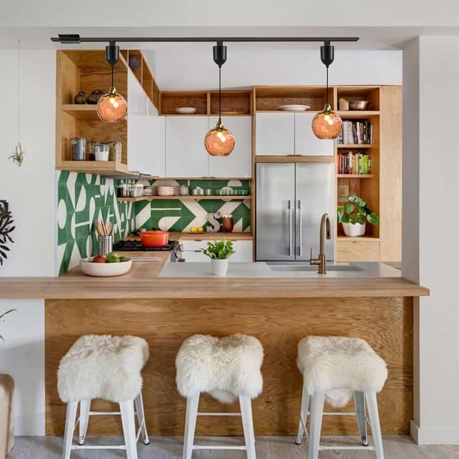 Orange hammered glass Juno track pendants over a kitchen bar, featuring adjustable height and vintage style lighting.