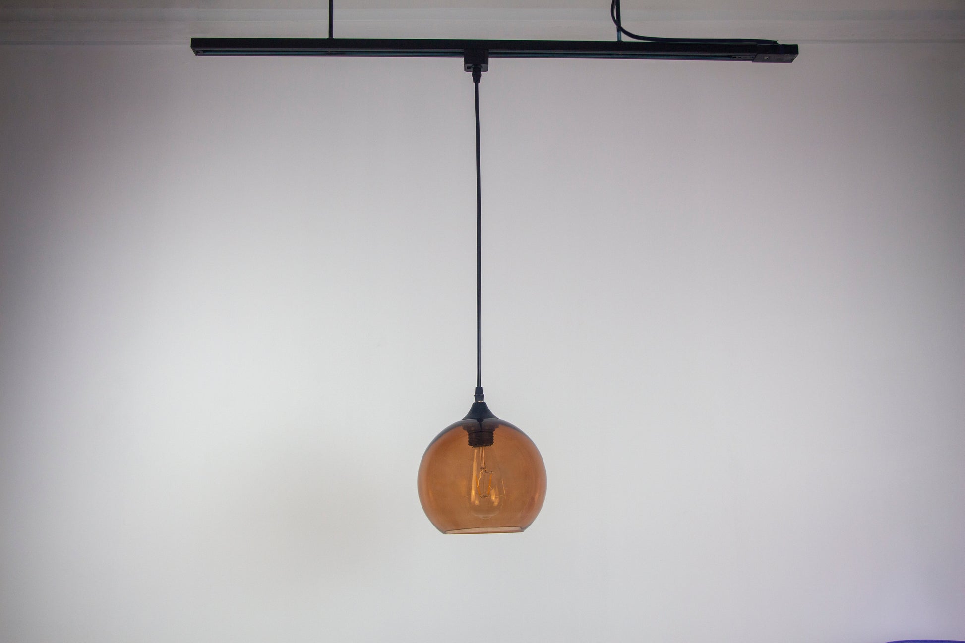 Modern track light pendant with amber glass globe. Industrial lighting fixture for track lighting, Kiven Lighting.