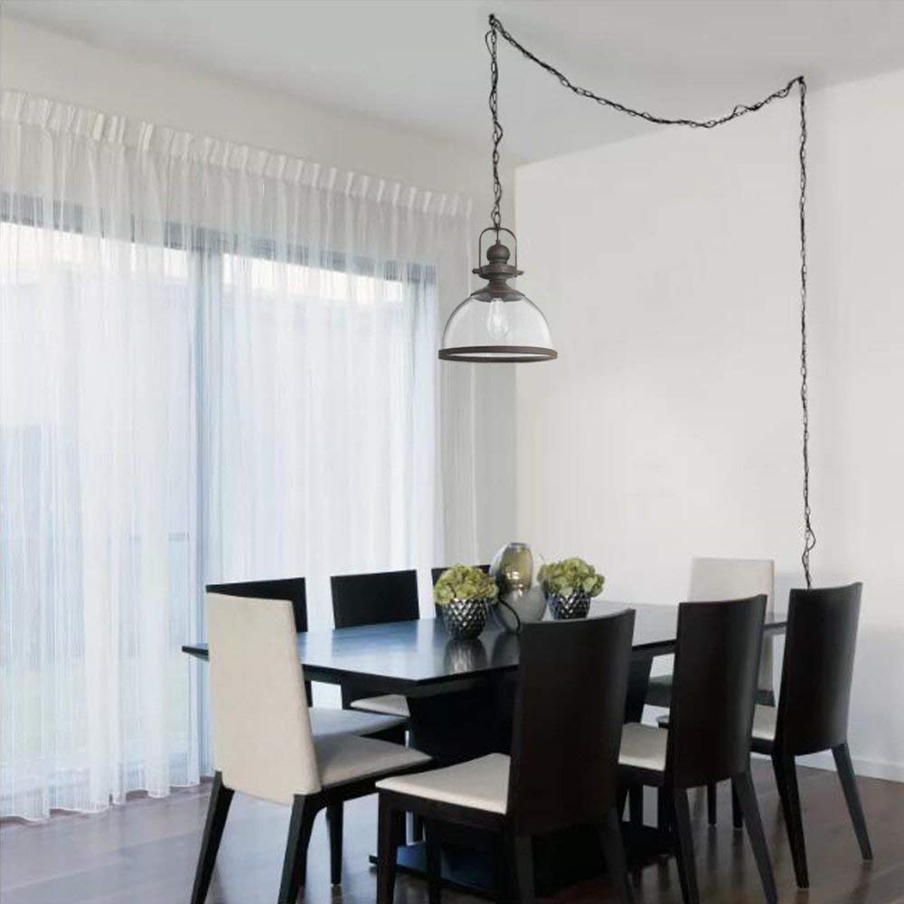 Modern dining room with black table and chairs featuring a glass pendant light with exposed bulb hanging from ceiling with visible chain wiring
