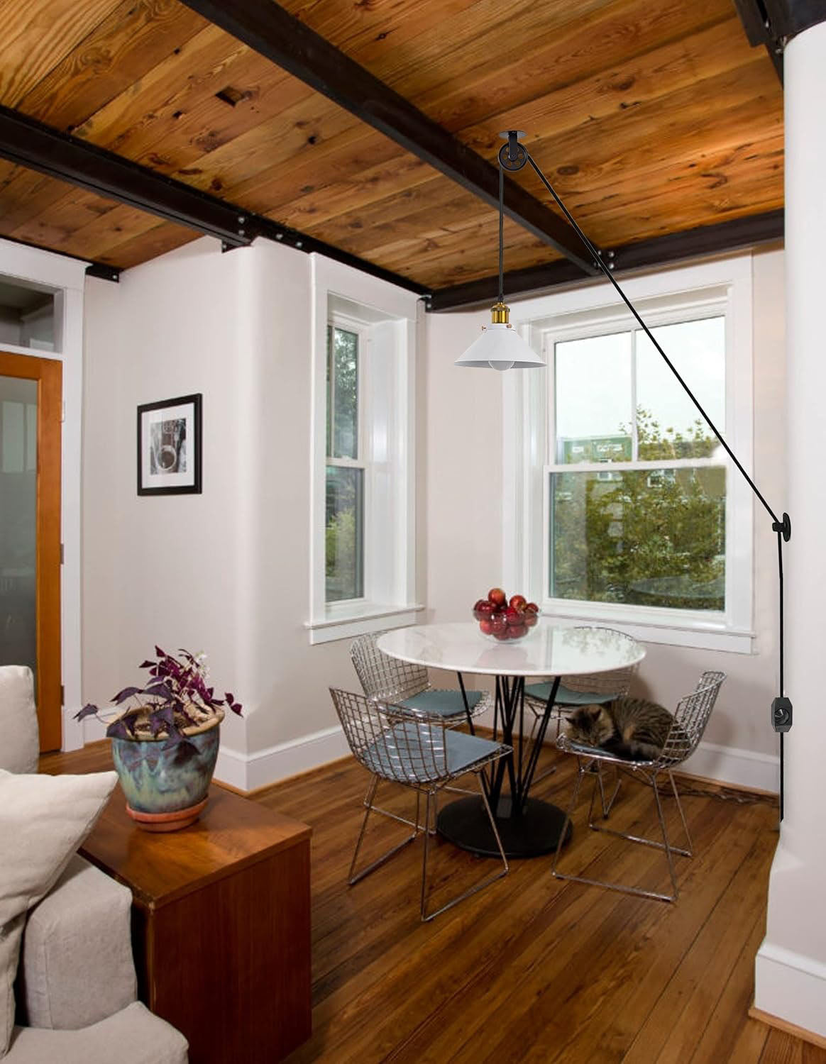 Industrial pulley pendant lamp with white cone shade over dining table. Plug-in cord by Kiven Lighting.