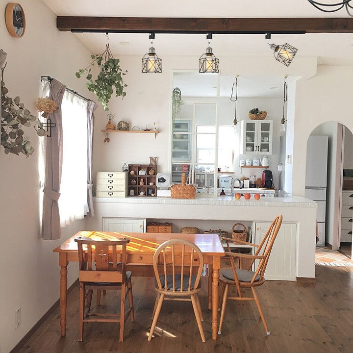 Black metal track light with Edison bulbs in a dining room, featuring rotatable, adjustable vintage design for home decor