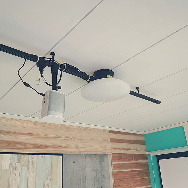Black ceiling projector mount with spotlight and adjustable angle, perfect for home theaters and presentations.