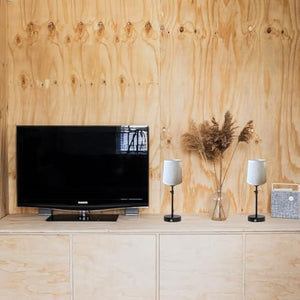 Kiven cordless table lamps on a wood cabinet beside a TV, showcasing a modern design and bedside lighting