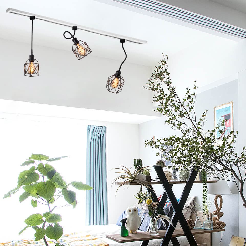 Black track lighting with geometric pendant lights illuminating a modern living room, Kiven Lighting's ceiling track lights.