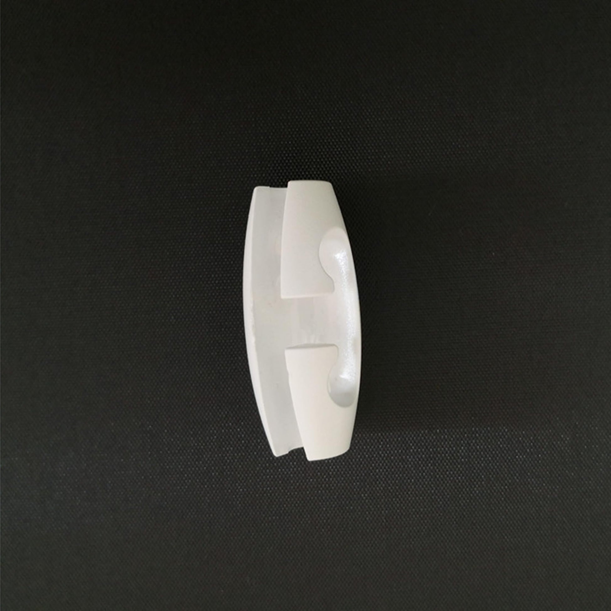 White plastic cord adjuster for pendant lights. Simple design for easy cord adjustment and a clean aesthetic.