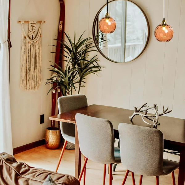 Orange hammered glass Juno pendants over dining table, adjustable height, vintage style lighting. Ideal for kitchen or bar.