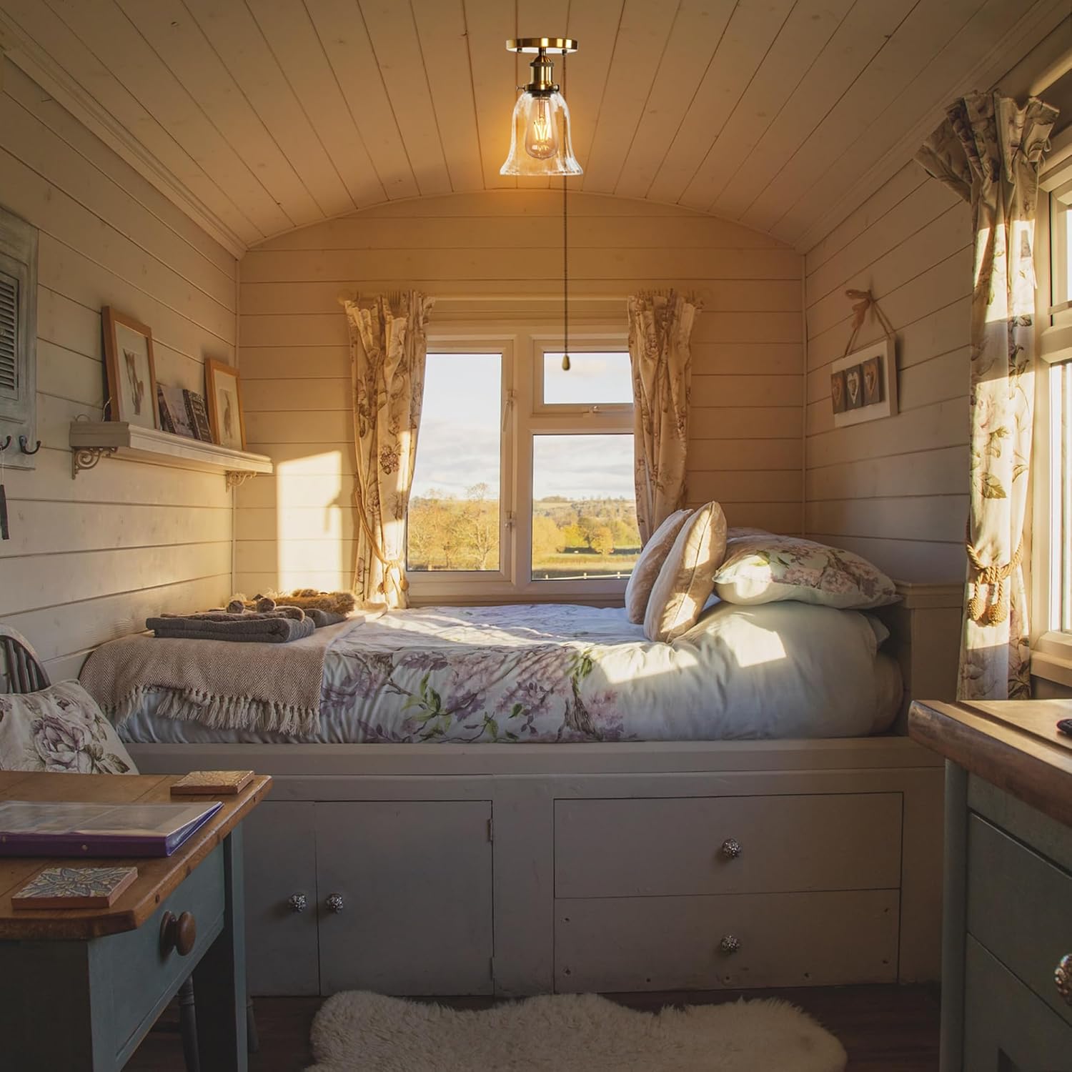 Gold RV Bell Ceiling Light. Clear glass shade, vintage style, perfect for RV lighting. Cozy interior with bed and window.