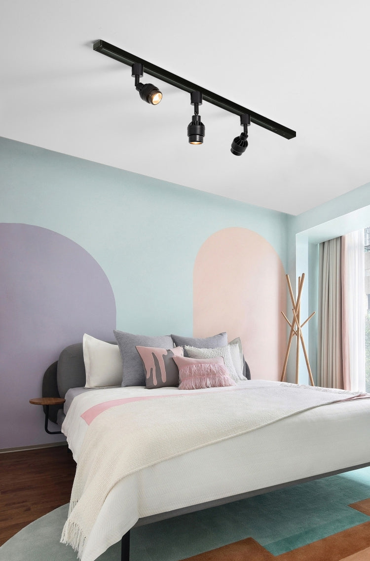 Black track lighting spotlight in bedroom, adjustable for wall painting illumination.