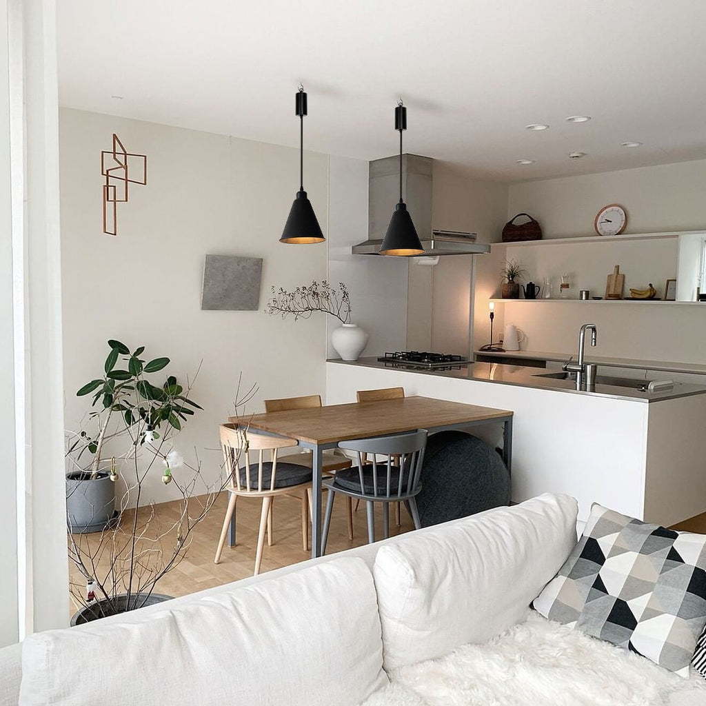 Black pendant lights with adjustable cord over dining table in modern kitchen, wireless design and dimmable LED bulbs