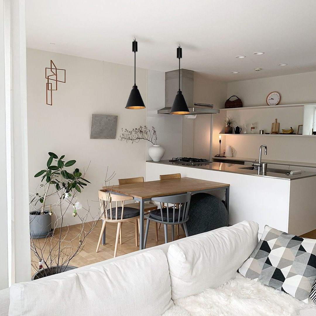 Black pendant lights with adjustable cord over dining table in modern kitchen, wireless design and dimmable LED bulbs