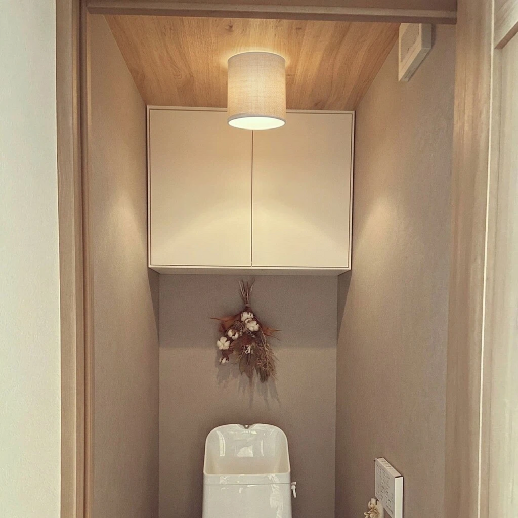 Modern minimalist fabric lamp shade mounted on ceiling socket in neutral bathroom interior