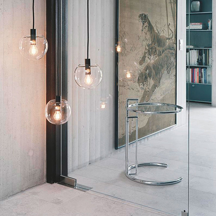 Track mount pendant lights with clear glass globes, ideal for kitchens or dining areas, showcasing modern and vintage design.