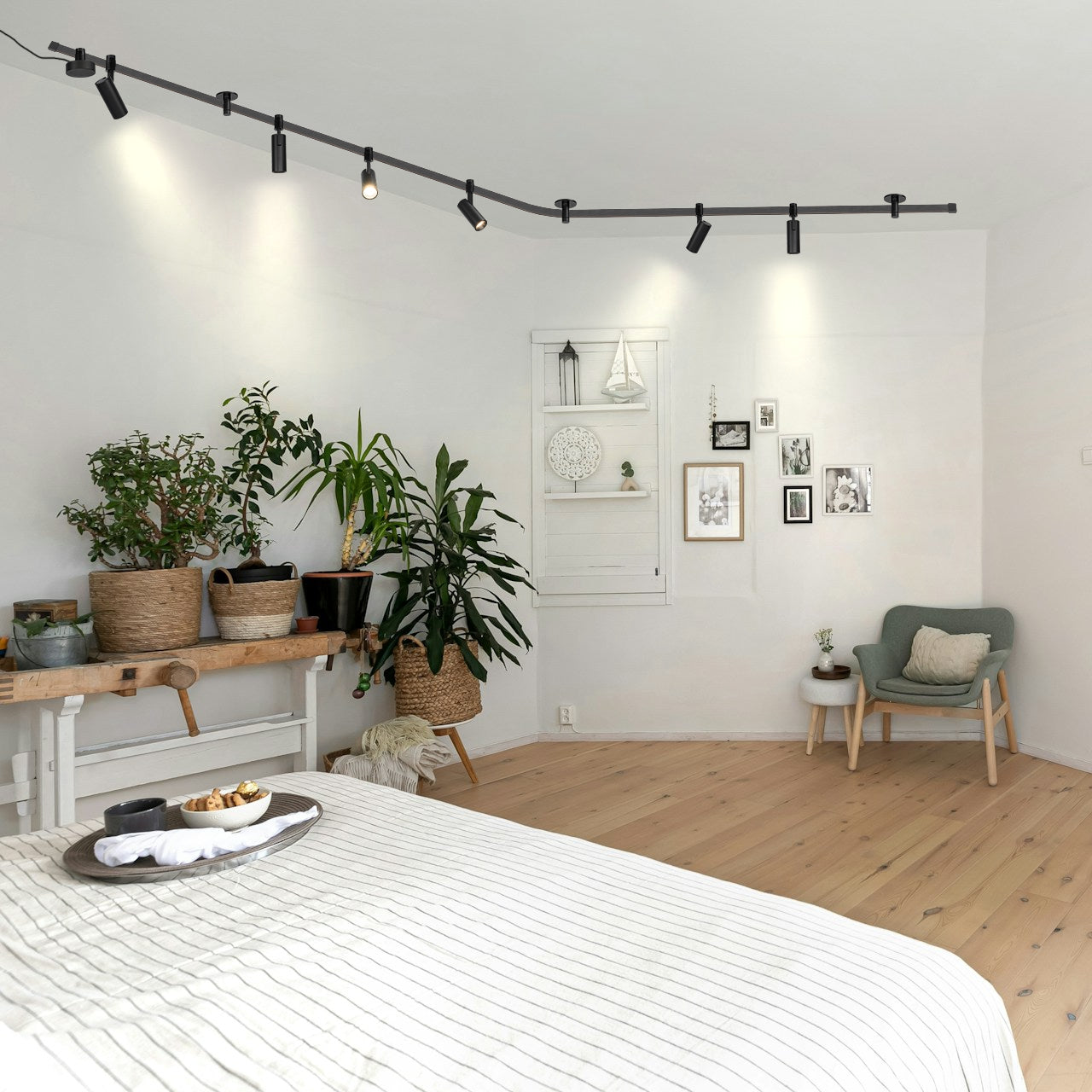 Black track lighting with spotlights in a modern bedroom setting, flexible design for kitchen or living room.