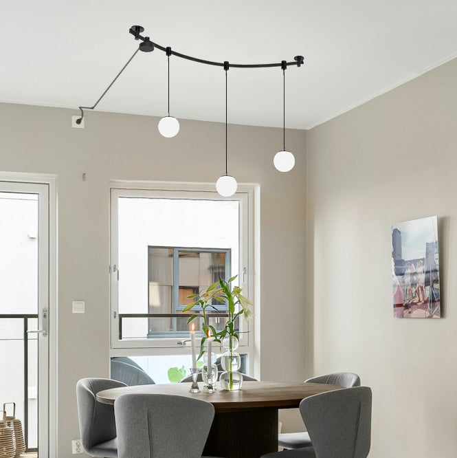 Black Kiven LED track light with three globe pendant lights, modular design, for kitchen or dining room lighting.