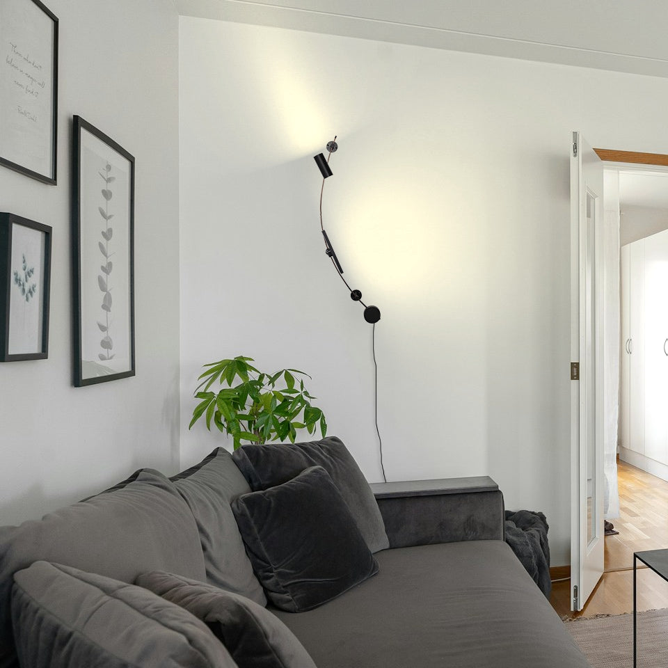 Black Kiven LED track light on white wall, curved design. Modern DIY lighting for living room or bedroom