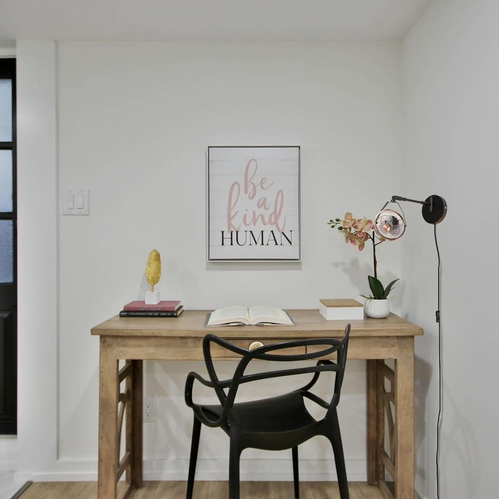 Industrial black wall mount fan with swing arm installed next to a home office wooden study desk