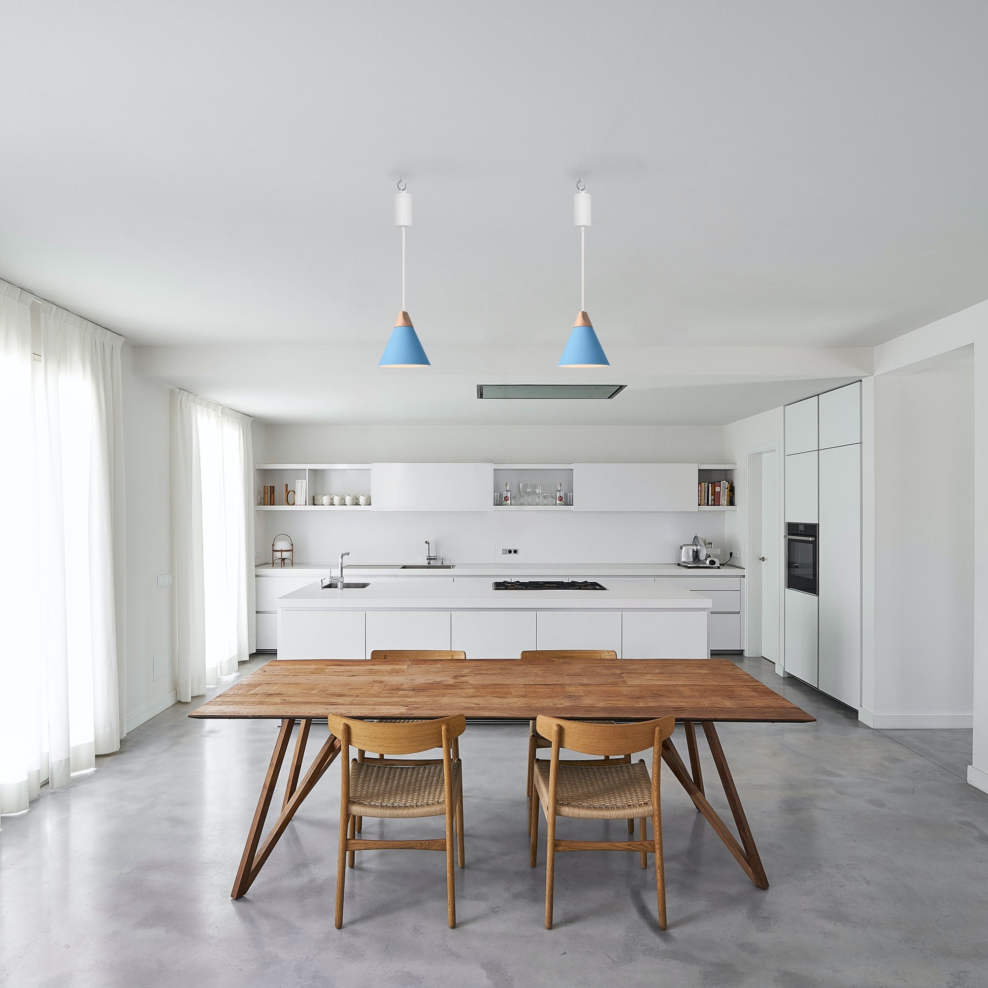Modern kitchen with blue cone pendant lights above wooden dining table and chairs, perfect for home and business spaces.
